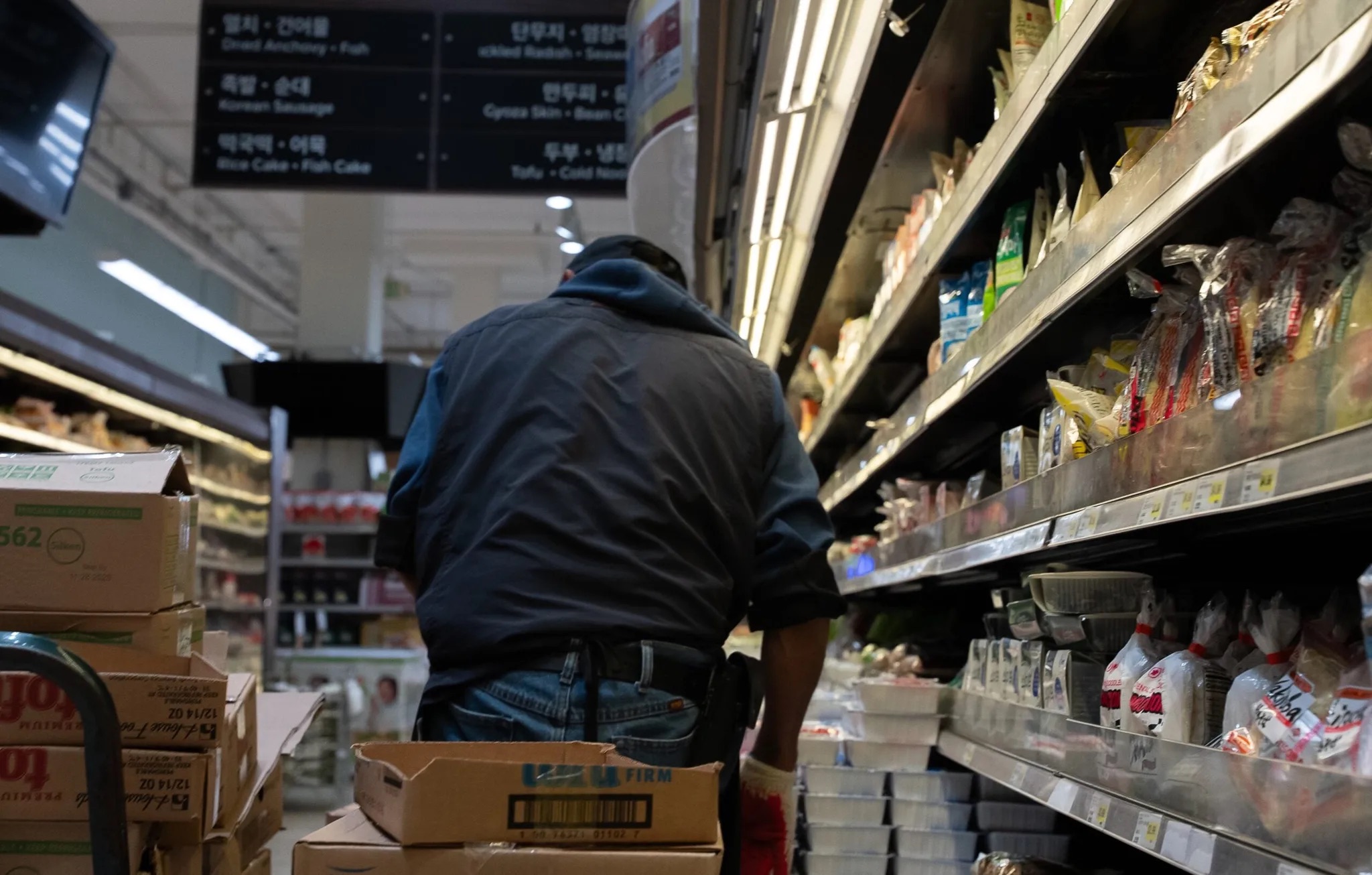 Grocery store worker restocking items at a grocery store